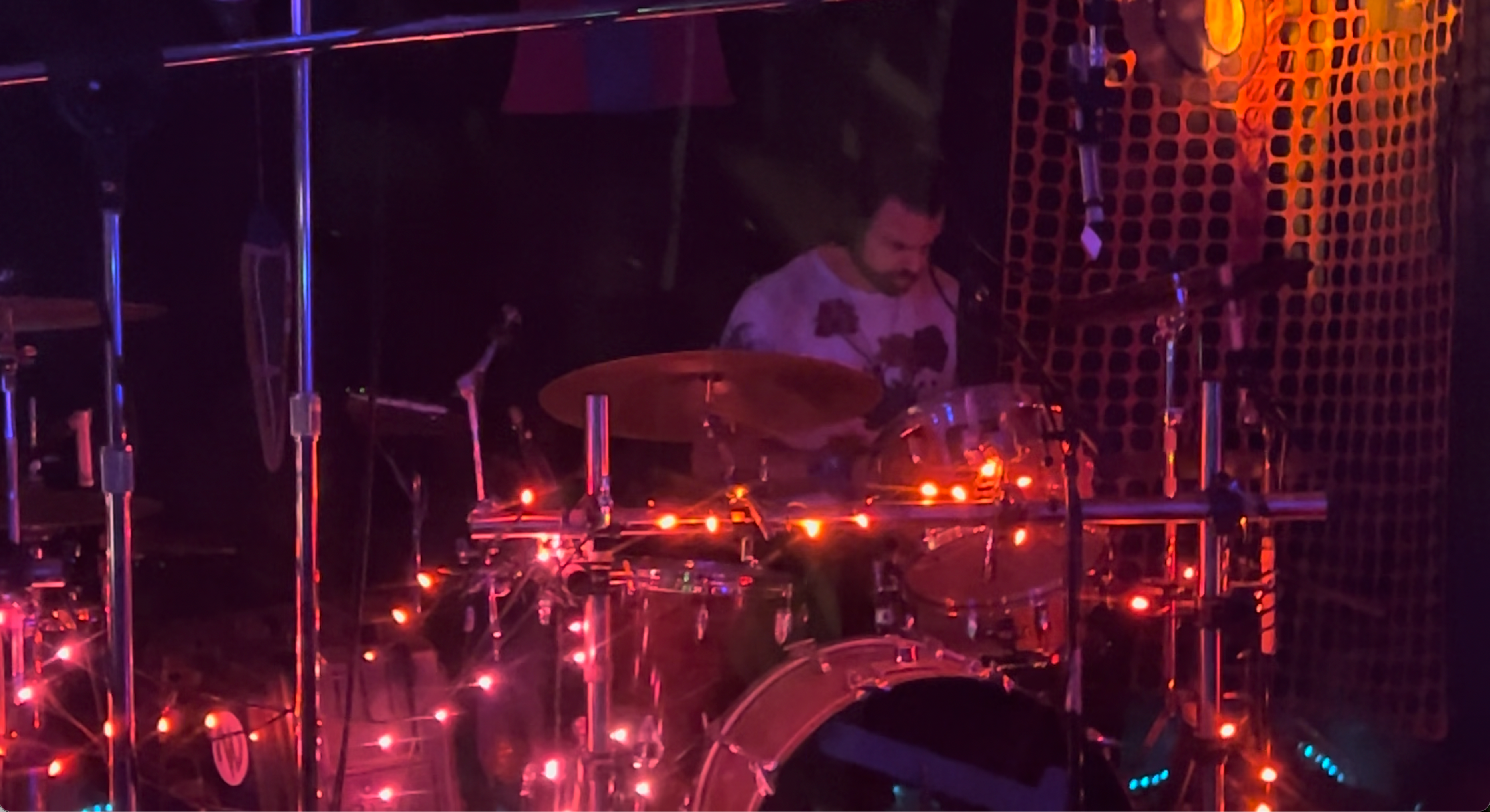 Matt on drums with neon stage lighting